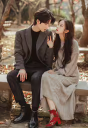 a young woman with long hair and a man in black and grey coat sitting next to each other,a young man and woman sitting next to each other on a bench