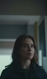 the woman in the black jacket is staring ahead