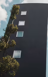 looking up at a modern building that has five windows