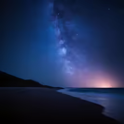the stars shine brightly over the water on the beach