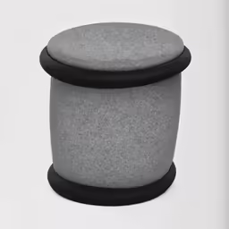 a grey ottoman sitting on top of a white table