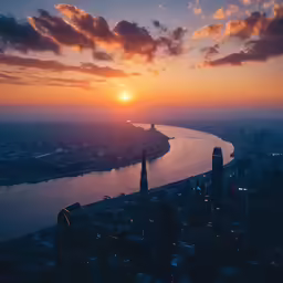 the sun setting over a large city overlooking the water