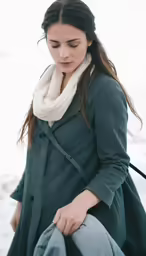 a woman that is looking down at a snowboard