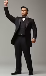 a man in a tuxedo raises his hand