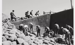 men are digging through the rocks at an area where they are working