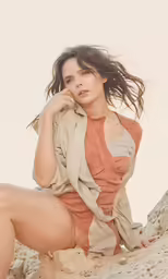 a young girl is posing in the desert with her hair blowing in the wind