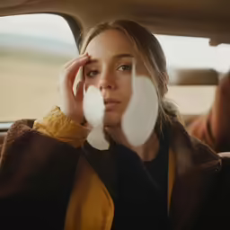 a woman sitting in the passenger seat of a car