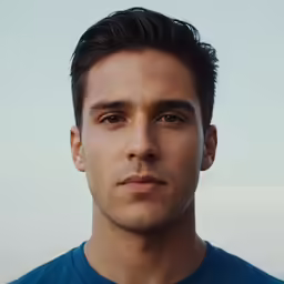 a man wearing a blue shirt and looking at the camera