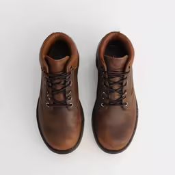 a pair of brown leather boots on a white surface