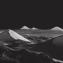 the sun is shining over a mountain range
