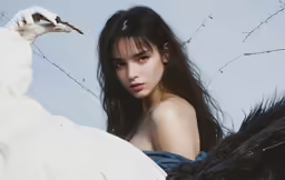 a naked young woman sitting next to a feather