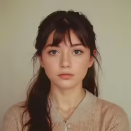 an asian woman with a braid wearing a beige shirt and sweater