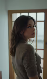 a woman standing next to a doorway and looking into the distance