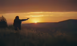 woman in a sunset view pointing at the sun