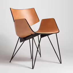 two brown leather chairs on black steel legs