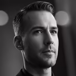 a man in a suit and tie looking to his left