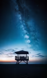 a small white structure with an open roof next to the ocean under the stars