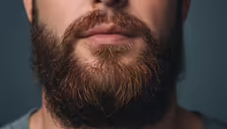 a bearded man with a shaved beard wearing sunglasses