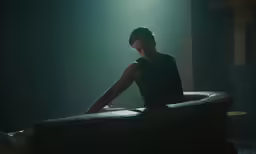a young man sitting in a dark room