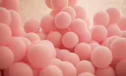 a bunch of small pink bubbles that are sitting on a table