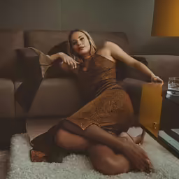 a woman sitting on a couch next to a table