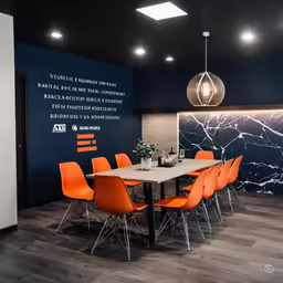 an office has bright orange chairs and a blue wall