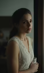 a beautiful young woman in a dress holding a cup