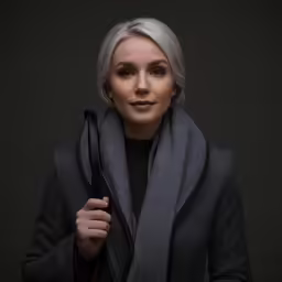 the beautiful blonde woman is wearing a black sweater