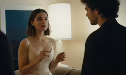 the woman in the white dress is standing next to a man in black