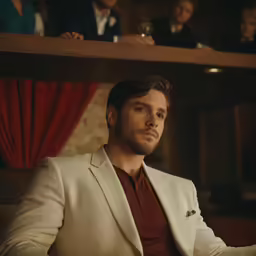 the man in the white suit is posing for a photo