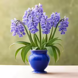 blue vase filled with purple flowers on top of a table