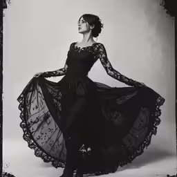 a woman in a black dress is posing for a portrait