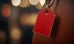 red tag hanging from a leather door handle
