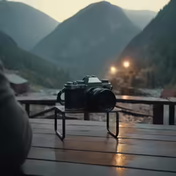 a camera on a metal stand with mountains in the background