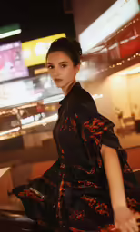 a beautiful woman wearing a black dress while standing next to boxes