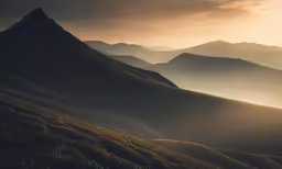 an arid, mountainous area with mountains covered in fog