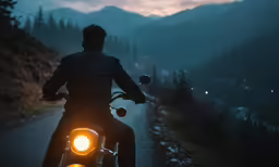 man riding his motorcycle on the road in the evening
