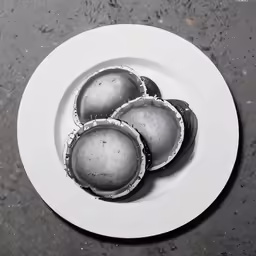 three chocolate - covered candies are shown on a white plate