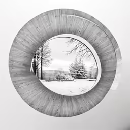 the view of a snow covered field through a circular window