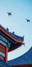 there are three planes flying in the sky above an asian building