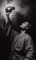 a man drinking water from a bottle in his hand