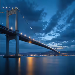 a large bridge spanning over water at night