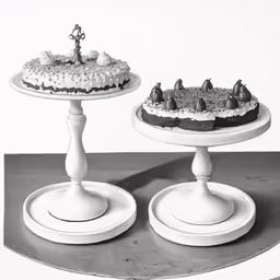 two small cakes on a white pedestal stand with a black and white photo of a man holding a statue