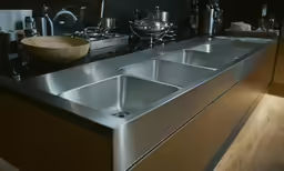 a kitchen sink that is stainless steel on a countertop
