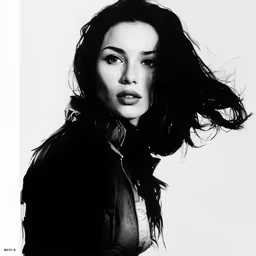 a young woman with long hair is posed,a woman in black leather jacket and white background