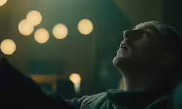 a man is looking up at some lights