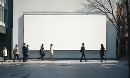 people walking past an empty white billboard outside