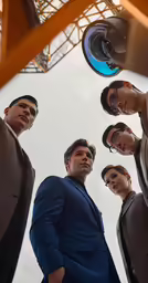 four men in suits standing under an arch