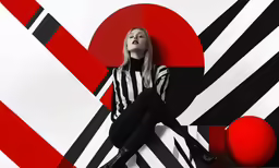a woman sitting on top of a chair next to a wall