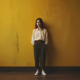 a person standing in front of a yellow wall